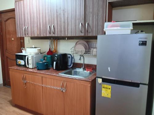 a small kitchen with a refrigerator and a sink at Toledo Jungle, Tropicana Garden City, Sumulong Highway, Marikina City, 1800 in Manila