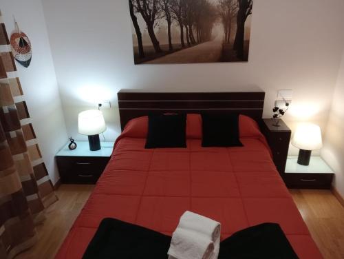 1 dormitorio con 1 cama roja y 2 lámparas en Piso Alerín II, en Silleda
