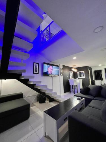 a living room with a couch and a tv at Kandi Suites 2BR with private Jacuzzi 500 Mbps internet in Angeles