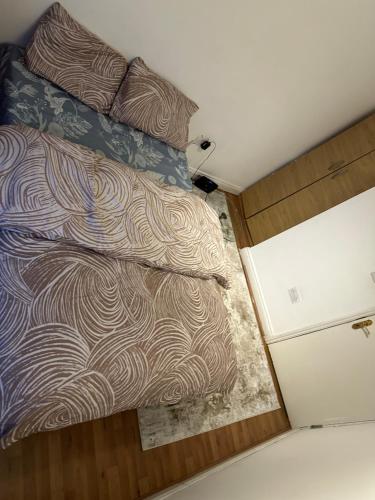 a bed in a small room with a bedspread and pillow at FLAT 5 37A LONDON ROAD in London