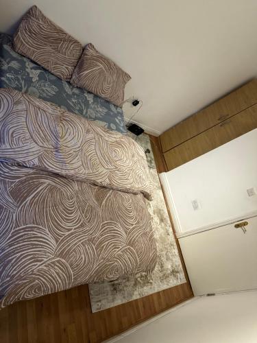 een bed in een kleine kamer met een sprei erop bij hsdfghgffhd in Londen