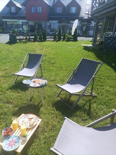 two chairs and a table with plates of food on it at Ostoja Karkonoska in Podgórzyn