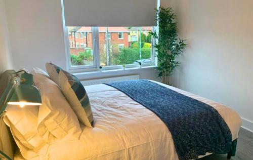 a bedroom with a large bed with a window at Shotley Bridge - Stunning 2 bedroom apartment in Consett