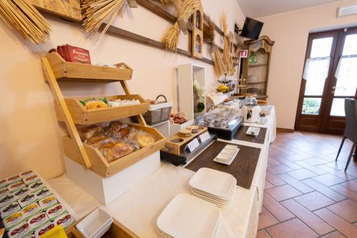 a bakery with a counter in a room with food at Hotel La Fertè in Asti