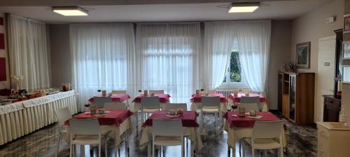 Hotel Bellavista Meublè في مونتي ايزولا: غرفة طعام مع طاولات وكراسي في غرفة