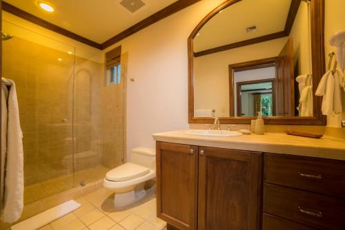 y baño con aseo, lavabo y ducha. en Los Suenos Resort Bay Residence 8C, en Herradura