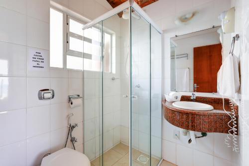 a bathroom with a glass shower and a sink at Village Paraíso in Florianópolis