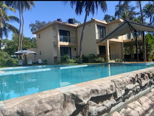 a house with a swimming pool in front of a house at Charchoma Restaurant in Mombasa