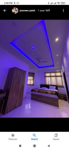 a room with two beds and a blue ceiling at Abhinandan House stay in Prayagraj
