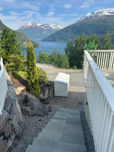 a white bench sitting on a staircase with a view of a lake at Leilighet med fantastisk utsikt in Stryn