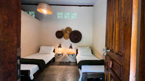 a room with two beds and two tables in it at Pousada Moreré in Ilha de Boipeba