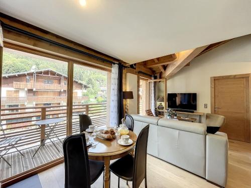 une salle à manger avec une table et une grande fenêtre dans l'établissement STELLA - Les Gets - Centre village, aux Gets