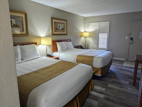 a hotel room with two beds and a window at Travelodge by Wyndham Pueblo in Pueblo