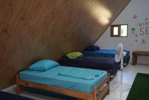 two beds in a room with a wooden ceiling at Casa de la playa in Santa Catalina