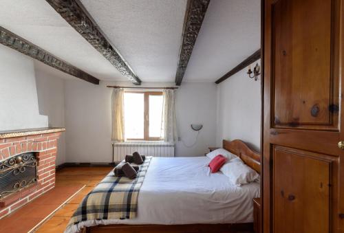 a bedroom with a bed in a room with a fireplace at Chalet Mila - Total Chalets - Catered Chalet in Bansko
