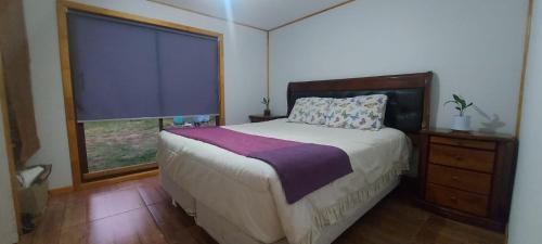 Un dormitorio con una cama grande y una ventana en casa de campo, en Villarrica