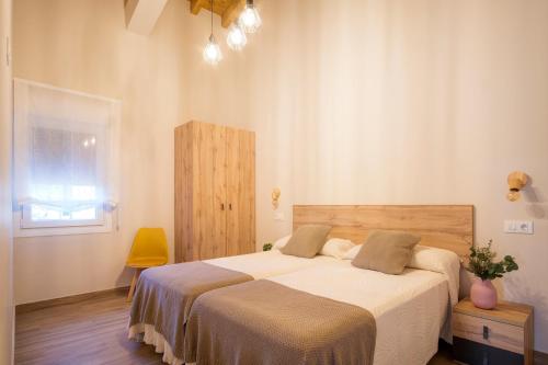 Apartamentos Alto Ubiro في ييرغانيس: غرفة نوم بسرير كبير وكرسي اصفر