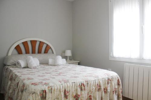 um quarto com uma cama com um cobertor e uma janela em Casa Gelina em Gijón