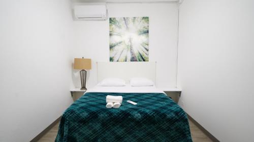 a bedroom with a bed with a green blanket at Caribbean Stars San Juan Airport in Carolina