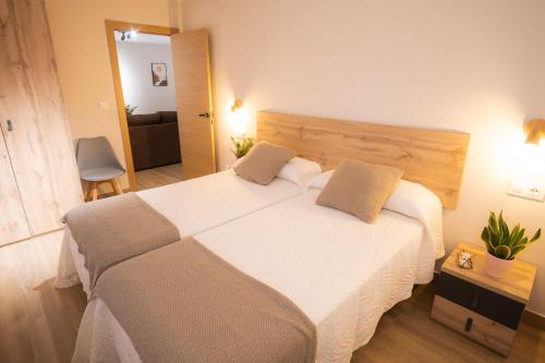 1 dormitorio con 1 cama grande con sábanas blancas en Apartamentos Alto Ubiro, en Liérganes