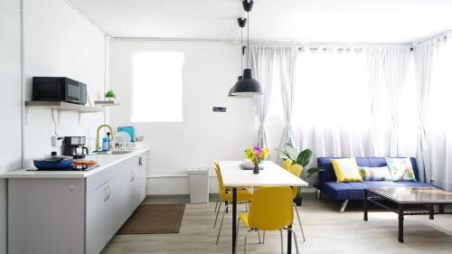a kitchen and living room with a table and yellow chairs at Caribbean Stars San Juan Airport in Carolina