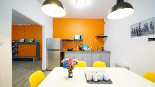 a kitchen with orange walls and a table and yellow chairs at Caribbean Stars San Juan Airport in Carolina