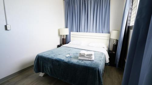 a bedroom with a bed with two towels on it at Caribbean Stars San Juan Airport in Carolina