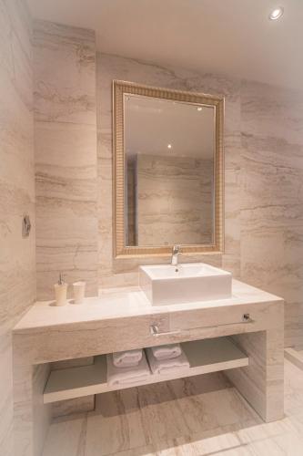 a bathroom with a sink and a mirror at Bellevue Villas with private pool in Hanioti
