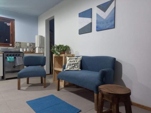 sala de estar con sofá azul y silla en El Molino cabañas en General Juan Madariaga