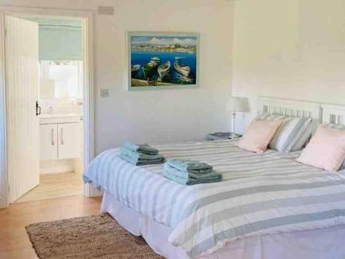 een slaapkamer met een groot bed en handdoeken bij Relaxing studio and garden in St Hilary in Cowbridge