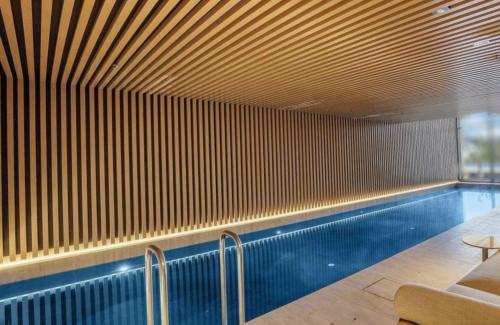 a swimming pool in a building with a wooden ceiling at Apartment G4 in Adelaide