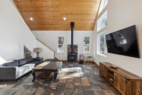 een woonkamer met een bank en een tv bij Tranquil Pine Mountain Retreat cabin in Pine Mountain Club