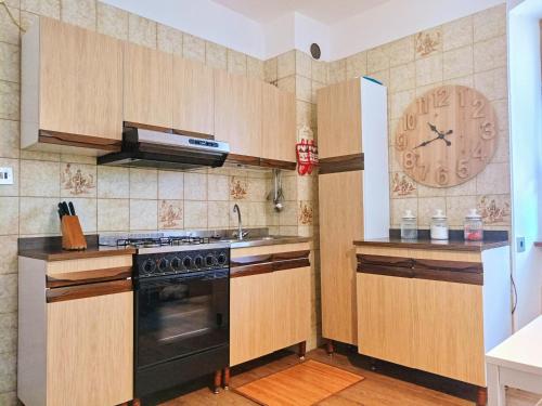 een keuken met een fornuis en een klok aan de muur bij 2 bedrooms apartement with city view balcony and wifi at Carisolo in Carisolo