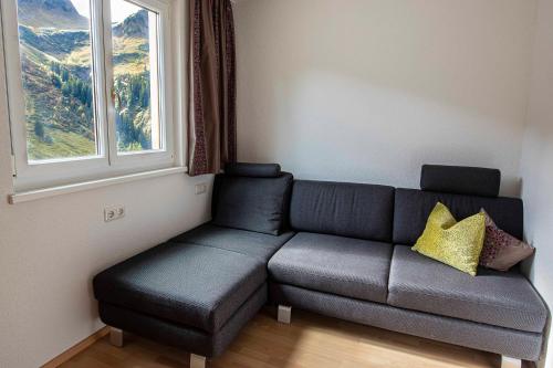 a couch in a living room with a window at Hotel Lucia - 3 Sterne Superior in Damuls