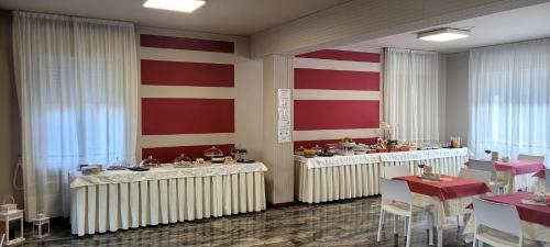 a restaurant with tables and chairs and red and white stripes at Hotel Bellavista Meublè in Monte Isola