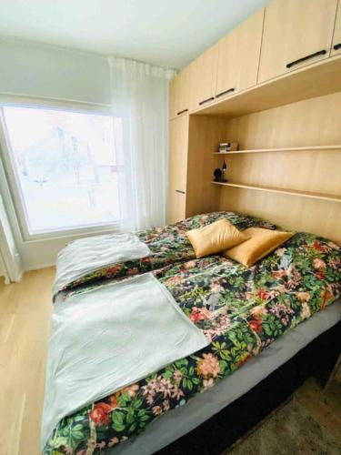 ein Schlafzimmer mit einem großen Bett mit Blumen darauf in der Unterkunft Kokkola Charm - Central Apartment by University Center in Kokkola