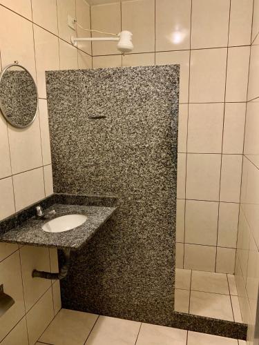a bathroom with a granite counter top with a sink at Hotel Glória in Niterói
