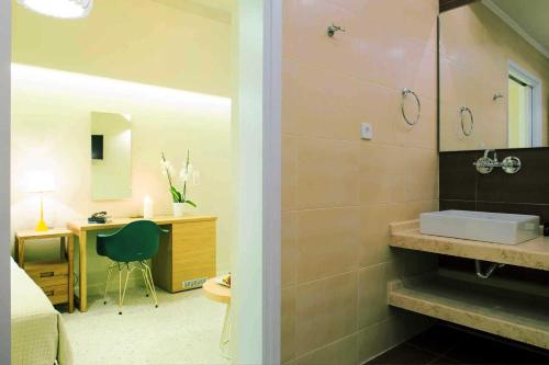 baño con ducha y lavabo y escritorio. en Athena hotel, en Nauplia