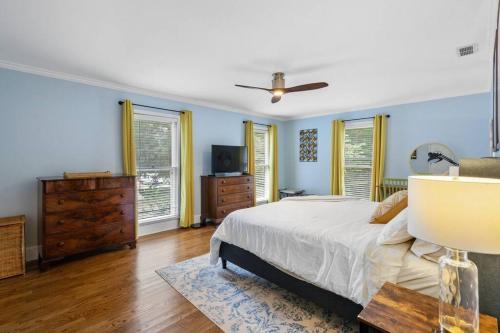 Schlafzimmer mit einem Bett, einer Kommode und Fenstern in der Unterkunft Cozy Home w/ POOL + BABY Gear in Prime Area in Charlotte