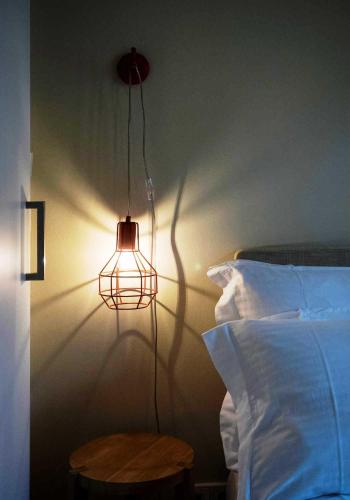a lamp on a wall next to a bed at Athena hotel in Nafplio