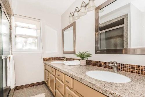 ein Badezimmer mit 2 Waschbecken und einem Spiegel in der Unterkunft Cozy Home w/ POOL + BABY Gear in Prime Area in Charlotte
