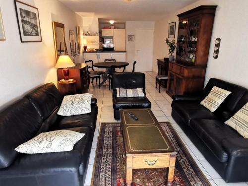 - un salon avec des canapés en cuir noir et une table dans l'établissement LES DUNES DE BLOSSAC 100m de la plage avec garage, à Les Sables-dʼOlonne