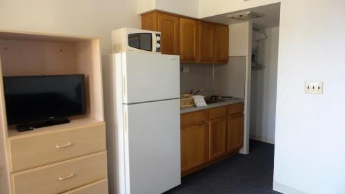 a kitchen with a white refrigerator and a tv at Golden Rail Motel in North Wildwood
