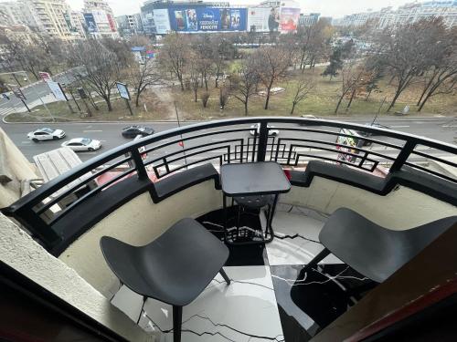 balkon z krzesłami i widokiem na ulicę w obiekcie Cozy Apartament in Center of Bucharest w Bukareszcie