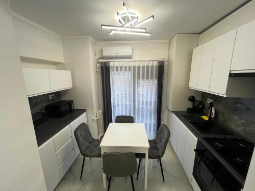 małą kuchnię z białym stołem i krzesłami w obiekcie Cozy Apartament in Center of Bucharest w Bukareszcie