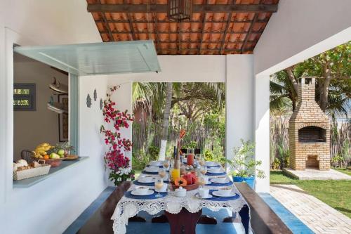 a dining room with a table with food on it at Beachfront 7-bedroom Villa in Taiba - Kitesurfing Paradise in São Gonçalo do Amarante