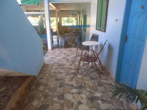eine Terrasse mit einem Tisch und Stühlen auf einer Etage in der Unterkunft POUSADA BELA VISTA in Conde