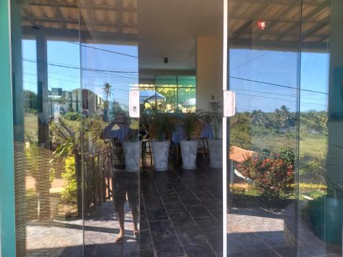 osoba stojąca przed szklanymi drzwiami w obiekcie POUSADA BELA VISTA w mieście Conde