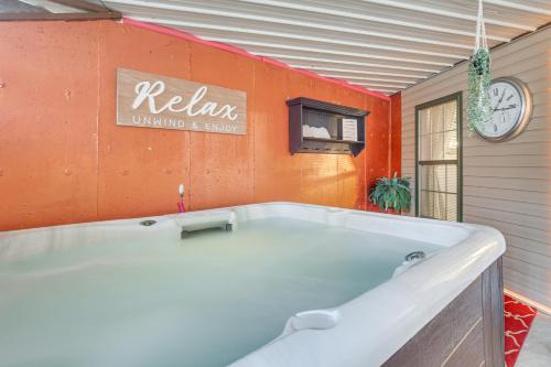 a bath tub in a room with an orange wall at Troy Apartment with Hot Tub, Pool Table and Fire Pit! in Troy