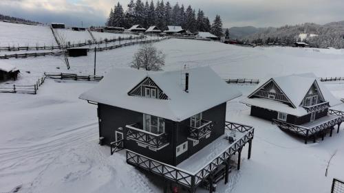 a house covered in snow on a snow covered field at Drevenice Horné Kysuce in Vysoká nad Kysucou